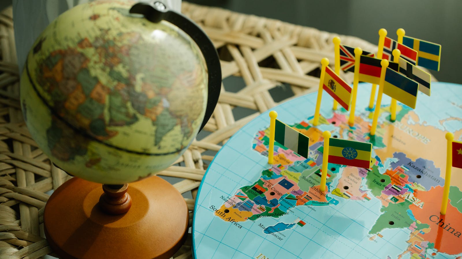 Globo terráqueo y mapa plano del mundo con marcadores de banderas de países que representan varios idiomas